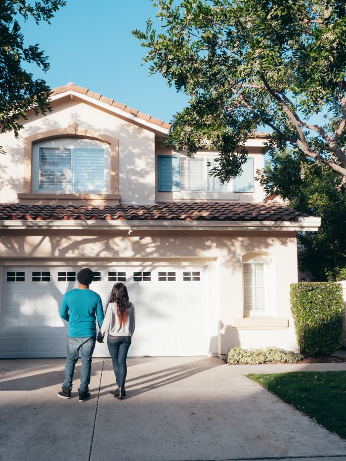 about-us A couple stands hand in hand, admiring their new house and life ahead.