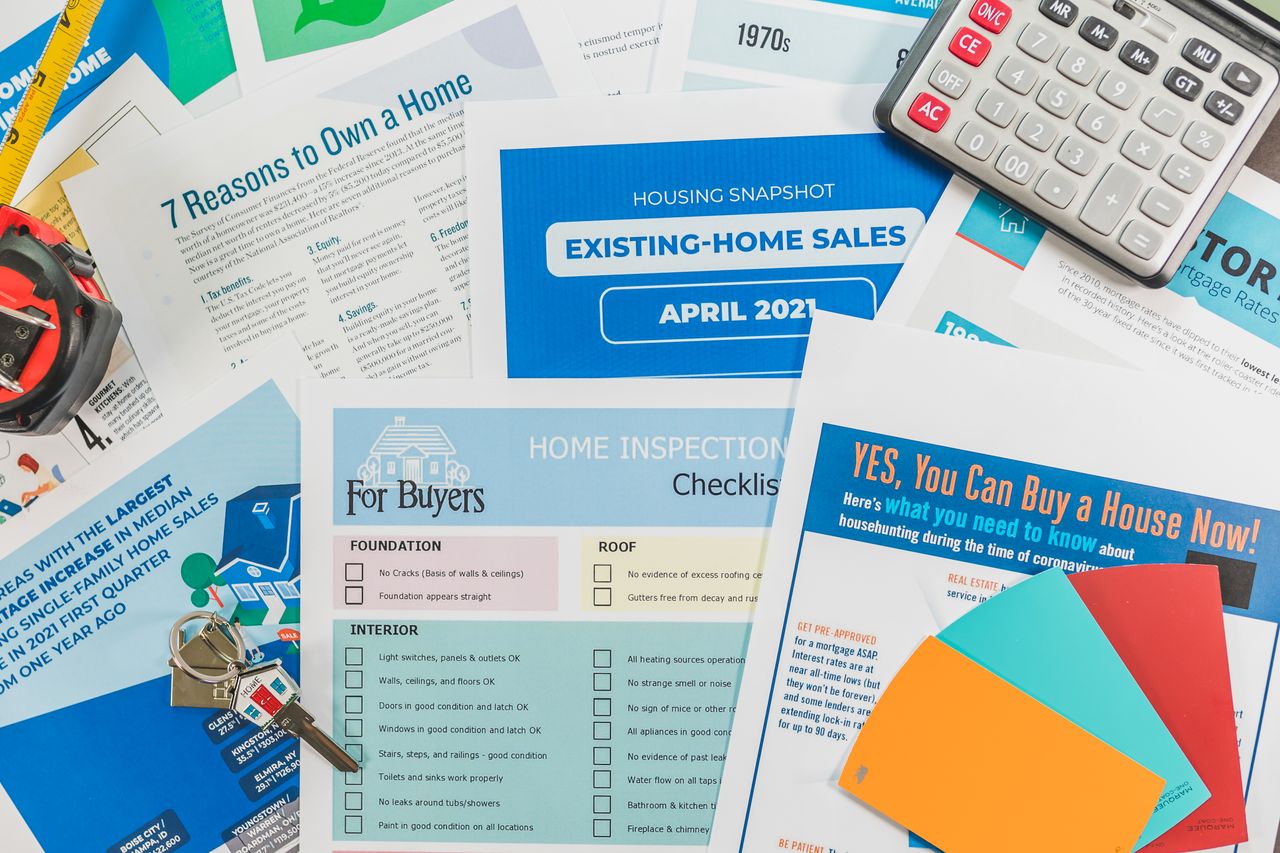 Mastering the First Impression: Your intriguing post title goes here Flat lay of real estate brochures, checklists, and a calculator for home buying.