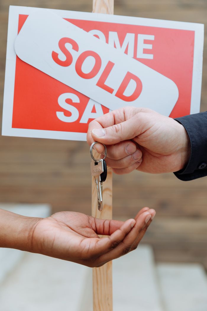 Crafting Captivating Headlines: Your awesome post title goes here Hands exchanging house keys in front of a sold sign, symbolizing real estate success.